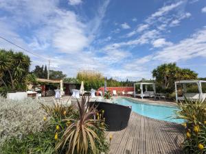 a swimming pool with a wooden deck next to a resort at Le Mas Del Cavalier in Baho