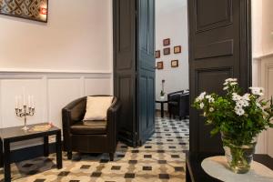 a waiting room with a chair and a vase of flowers at Best Western Le Comtadin in Carpentras