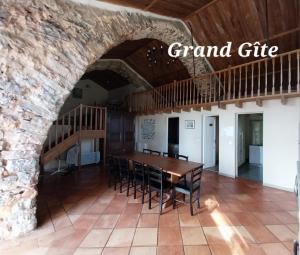 a dining room with a table and a stone wall at Escale de la Jurade in Rogues