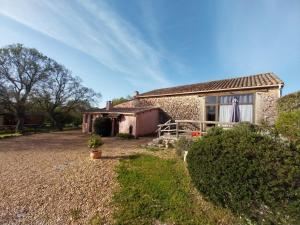 an old stone house with a porch and a yard at Escale de la Jurade in Rogues