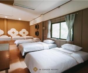 a row of beds in a room at SN Garden in Ban Bo Hin