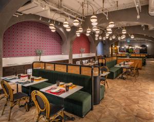 a restaurant with tables and chairs and red walls at Sindhorn Midtown Hotel Bangkok, Vignette Collection by IHG in Bangkok