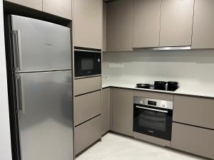 a kitchen with a stainless steel refrigerator and microwave at Eaton Residence Suites KLCC in Kuala Lumpur