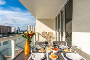 a table with plates of food on a balcony at Golden Bay 1003 in Miami Beach