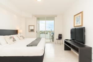 a bedroom with a bed and a flat screen tv at Golden Bay 1003 in Miami Beach +46 photos