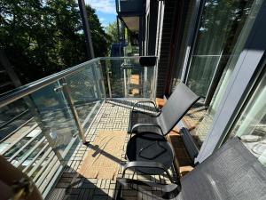 a balcony with two chairs and a bench on a house at Apartamentai prie Kalnų parko in Vilnius +2 photos