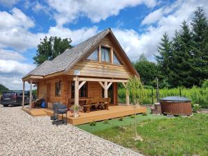 a log cabin with a picnic table and a gazebo at Domek z bala na Podlasiu z balią ogrodową in Suszcza