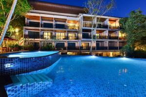 a swimming pool in front of a building at night at Dusit Buncha Koh Tao by Riya Group in Ko Tao