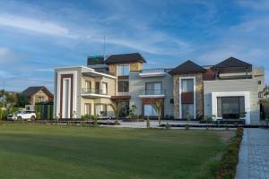 a large house with a lawn in front of it at Green Galaxy Villa in Amritsar