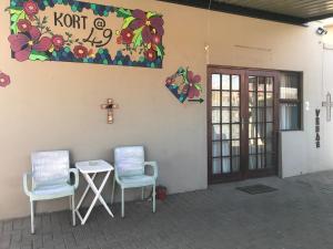 two chairs and a table and a cross on a wall at Cottage 49 in Parys