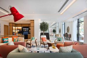 eine Lobby mit Sofas, Tischen und Stühlen in der Unterkunft Rove JBR in Dubai