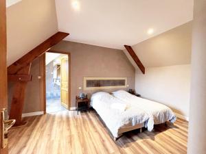 a bedroom with a large bed and a wooden floor at La longère T3 - Au Golf de Bellême - Parking - Wifi - 4 Pers in Bellême