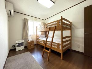a bedroom with two bunk beds and a window at Mountain View Lodge in Furano