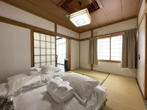 a bedroom with two beds with towels on them at Mountain View Lodge in Furano