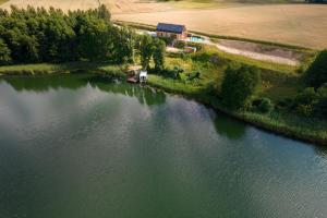 an aerial view of a lake with a house at Ostoja Skarlin in Mikołajki Pomorskie