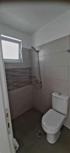 a bathroom with a white toilet and a shower at Lady S Holiday Studio in Lampi +11 photos