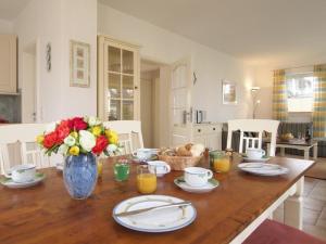 a dining room table with a vase of flowers on it at Ostseeblick Ferienhaus in Barendorf