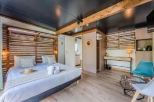 a bedroom with a large bed and a desk at Hôtel Le Grain de Sable in Arès