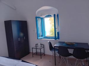 a dining room with a table and a window at Volto Studio in Kythira +7 photos