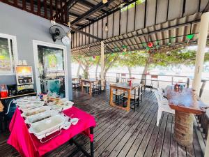 a restaurant with a table with plates of food on it at Poolsawat Villa - SHA Plus in Lamai