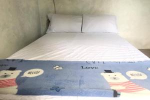 a bed with a blanket with hello kitty on it at Hotel O Homestay Banyumili Samigaluh in Semigaluh