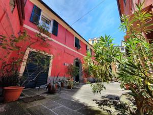 a red building with plants in front of it at Boutique Hotel Novecento in La Spezia