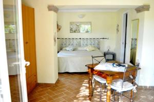 a bedroom with a bed and a table and chairs at Hotel Tirrena Bike & Country Hotel in Portoferraio