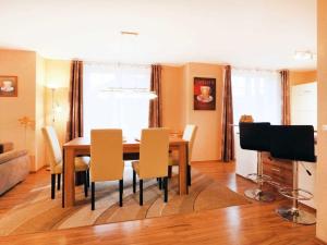 a dining room with a table and chairs and a television at Schwannest 1 in Groß Schwansee