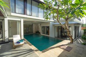 a villa with a swimming pool in front of a house at Luxury Marshanda villa in Jimbaran