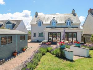 una casa con patio y flores en el patio en Llain Gwynfor, en Haverfordwest