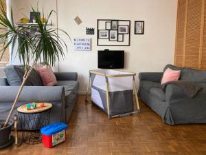 a living room with two couches and a plant at St Catherine - Sweet home - Bxl - Studio Apartment with city view in Brussels