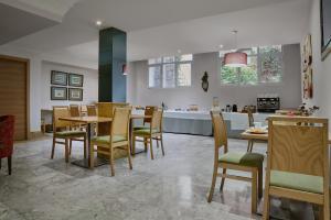 a dining room with tables and chairs and a kitchen at Reyes Católicos in Seville