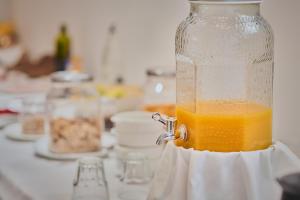 a glass jar filled with orange juice on a counter at Reyes Católicos in Seville