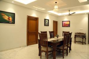 comedor con mesa de madera y sillas en Cosy Cottage en Chandigarh