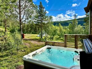 a jacuzzi tub in the backyard of a house at Bjørnfjell Mountain Lodge in Alta