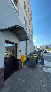a building with tables and chairs in front of a building at Apartament Rodzinny Nad Morzem, Gdynia in Gdynia