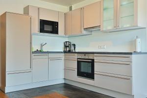 a white kitchen with white cabinets and appliances at Bregenz in Bettnau