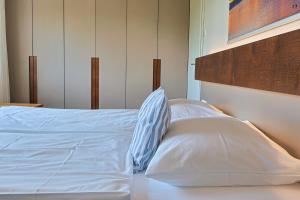 a bed with white sheets and a wooden head board at Bregenz in Bettnau
