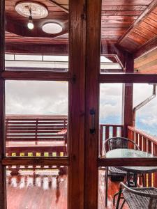 a view from a window of a table and chairs on a balcony at เมฆสวรรค์ ภูทับเบิก in Ban Maeo Thap Boek