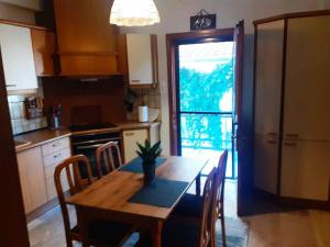 a kitchen with a wooden table with chairs and a window at GUSTO Apartment 2 in Orestiada
