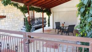 a porch with a bench and a table with chairs at GUSTO Apartment 2 in Orestiada