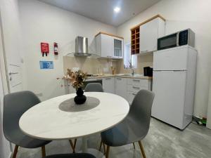 a kitchen with a table and chairs and a refrigerator at Ta Nenu Maisonette near Valletta & the Three Cities in Paola