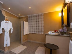 Baño con una bata blanca colgada en la pared en Hill Rise Luxury Villa & Stables by Edwards Collection, en Nuwara Eliya 49 fotos más