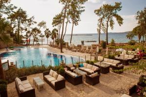 une image d'une piscine avec des canapés et des chaises dans l'établissement Wome Deluxe Hotel - Halal All Inclusive, à Avsallar