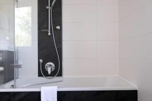 a bathroom with a shower with a bath tub at Säntis in Bettnau +4 photos
