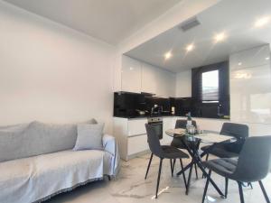 a living room with a couch and a table with chairs at Luxury Living Peramos in Nea Peramos