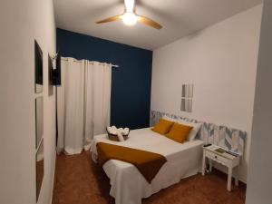 a bedroom with a white bed with a blue wall at El Molino Hostal-Restaurante in Jarafuel