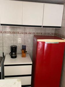 una cucina con frigorifero rosso accanto a un bancone di casinhavila130 a Salvador