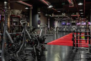 Ein Fitnessstudio mit rotem Teppich und Reihen von Fitnessgeräten in der Unterkunft Rove JBR in Dubai