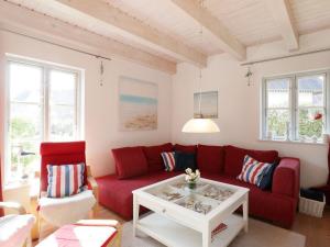 a living room with a red couch and a table at Strandkörbchen in Groß Schwansee